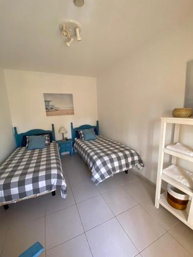 a room with two beds and a shelf at Beach Front Villa VV in Corralejo