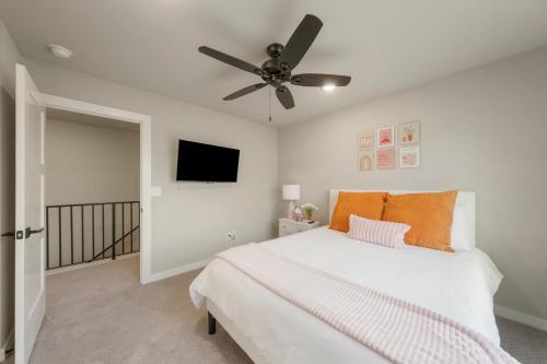 a bedroom with a bed and a ceiling fan at The Rose Retreat - Walk to the Broken Arrow Rose District in Broken Arrow