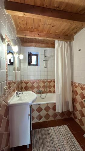 a bathroom with a sink and a shower and a tub at Moinhos do Paneiro in Santiago do Cacém