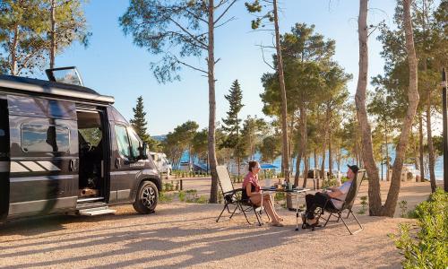a group of people sitting in chairs next to a van at Aminess Style Camping Avalona Resort - Pitches in Povljana