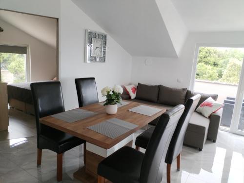 Un comedor con una mesa y un sofá. en Apartman Ivano, en Krnica
