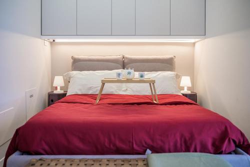 a bed with a red blanket and a table on it at Tiny House Tower in Fidenza