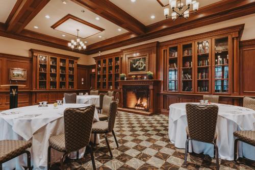 a dining room with tables and chairs and a fireplace at Pillar and Post Inn & Spa in Niagara on the Lake