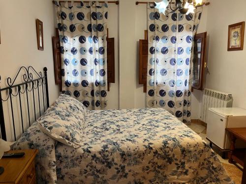 a bedroom with a bed with a blue and white comforter at Hostal Moraima in Capileira