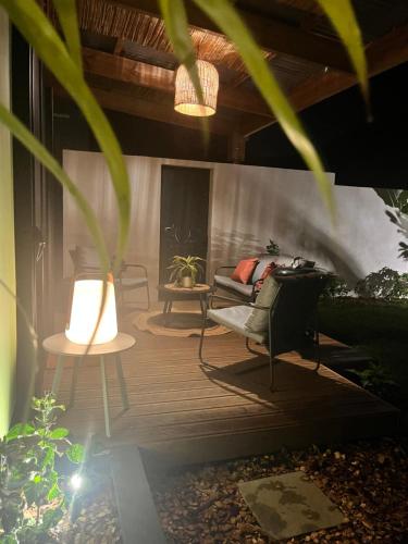 a patio with a couch and chairs on a wooden deck at L'Ecrin PEI in LʼEntre-Deux
