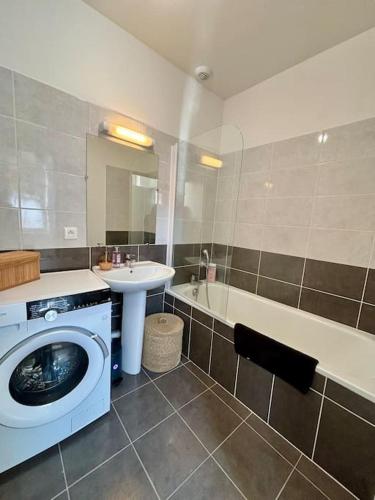 une salle de bains avec lave-linge et lavabo dans l'établissement Le Charmant Au cœur de Dieppe 2ème étage 6 personnes, à Dieppe