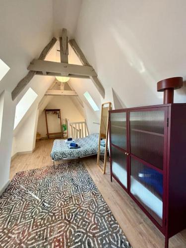 une chambre mansardée avec un banc et un tapis dans l'établissement Le Charmant Au cœur de Dieppe 2ème étage 6 personnes, à Dieppe