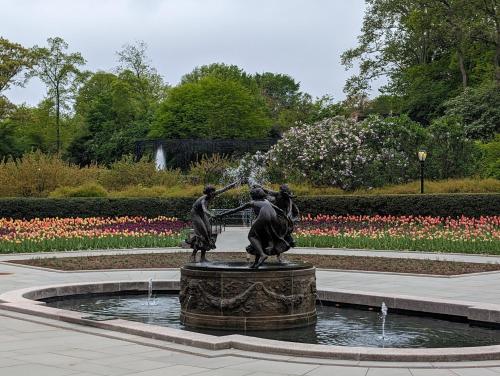 a statue of two women in a fountain in a park at THE CENTRAL PARK EAST by THE MUSEUM MILE in New York