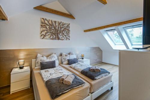 dwa łóżka w pokoju z dwoma oknami w obiekcie AusZeit Steiraland 5 mit überdachter Terrasse, privaten Garten und Parkplatz w mieście Judendorf