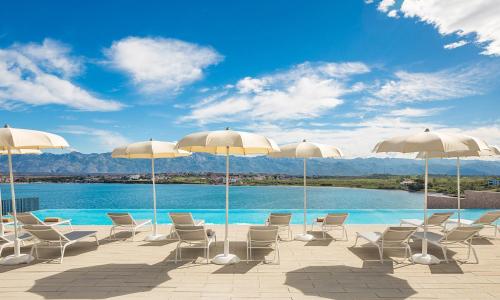 a group of chairs and umbrellas next to a pool at Aminess Style Camping Avalona Resort - Pitches in Povljana