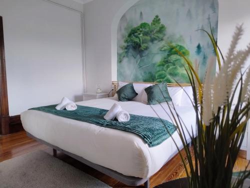 a bedroom with a bed with a painting on the wall at Chavarri Etxea, casa indiana XBI00149 in Biáñez