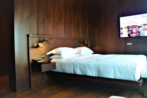 a bedroom with a large bed with a wooden wall at Hyatt Centric Levent Istanbul in Istanbul