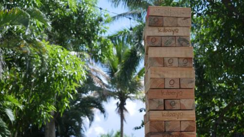 a wooden pillar with words on it in front of trees at Kibayo Lagoon Villa in Cabarete