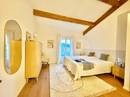 une chambre avec un lit et un grand miroir dans l'établissement Maison d’Oléa, à Bonnieux