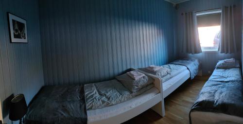 two twin beds in a room with a window at Northern Dream Lofoten in Hovdan