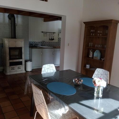 une cuisine avec une table et des chaises ainsi qu'une cuisine avec une cuisinière dans l'établissement le bien l'authie, à Colline-Beaumont