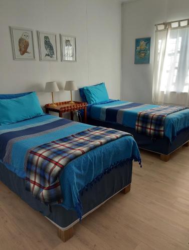 a bedroom with two beds and a table with lamps at Gulls Way in Keurboomstrand