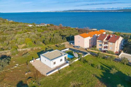 an aerial view of a house and the water at Orchid Stay in Ždrelac