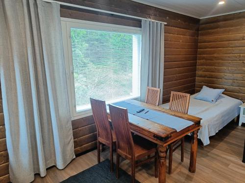 ein Esszimmer mit Tisch und Stühlen und einem Fenster in der Unterkunft 4B in Syöte