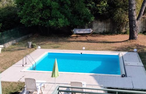 une piscine avec deux chaises et un parasol dans l'établissement Villa indépendante avec piscine au rdc, à Nyons