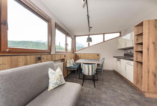 a living room with a couch and a table and some windows at Appartements Erzherzog Johann in Schladming