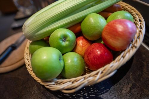 a basket of apples and celery on a table at Appartements Erzherzog Johann in Schladming