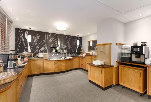 a large kitchen with wooden cabinets and appliances at Appartements Erzherzog Johann in Schladming
