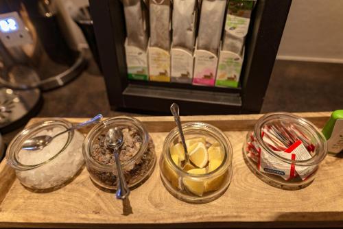 a wooden tray with three jars of food on it at Appartements Erzherzog Johann in Schladming