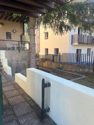 a white wall with a fence next to a building at Casa Vacanza Regina in Roccaraso