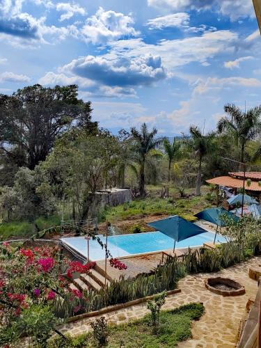 a resort with three swimming pools and flowers at CABAÑAS PAL SAN GIL in San Gil