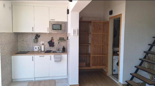 a kitchen with white cabinets and a microwave at Aloft Apartment in Budva