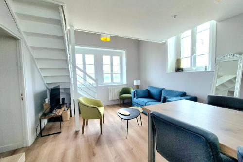 un salon avec un canapé bleu et une table dans l'établissement Bright duplex with magnificent sea views, à Saint-Malo