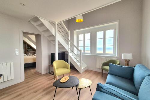 un salon avec un canapé bleu et des chaises dans l'établissement Bright duplex with magnificent sea views, à Saint-Malo