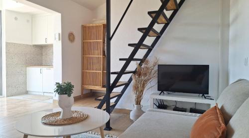a living room with a staircase and a tv at Aloft Apartment in Budva