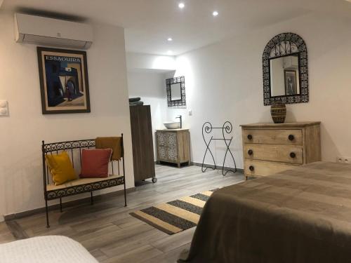 a bedroom with a bed and a dresser and a mirror at L'atelier in Capestang