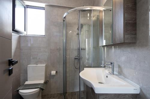 a bathroom with a toilet and a sink and a shower at Nick and Helen in Rethymno Town