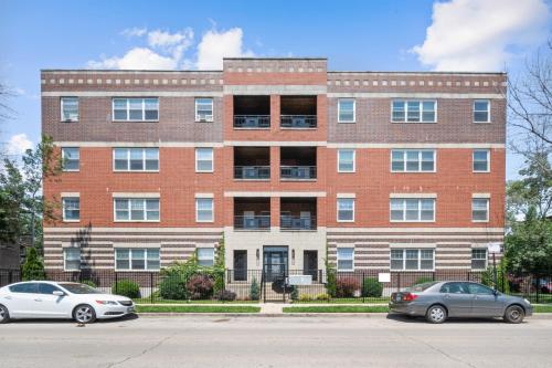 two cars parked in front of a brick building at Kenwood Apartments, Downtown Hyde Park in Chicago