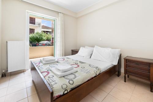 a bedroom with a bed with a table and a window at Abatis CityHome in Lefkada