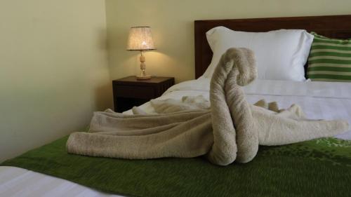 a towel sitting on top of a bed at Nick Homestay Bali in Uluwatu