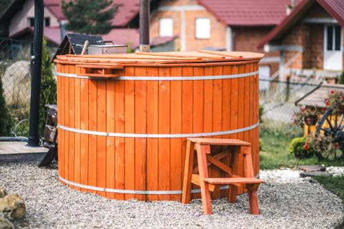 a wooden barrel with a wooden stool in a yard at Vila Deniri in Zlatibor