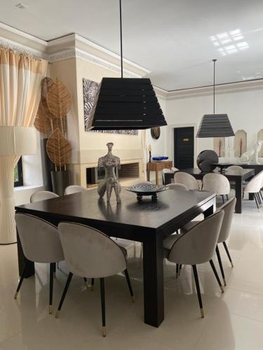 a dining room with a black table and chairs at Villa Mano in Marrakech