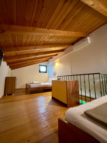 a bedroom with two beds and a wooden ceiling at Villa Georgia in Kastrosikia