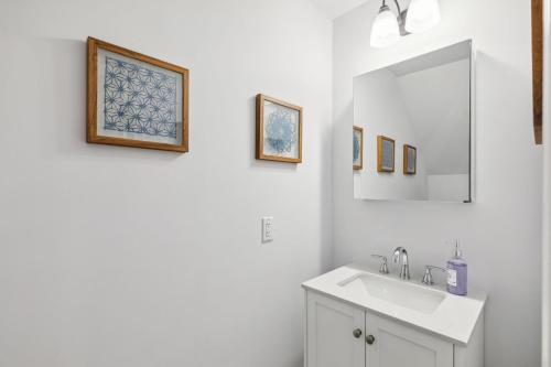 a white bathroom with a sink and a mirror at Stay at Luna at Convention Center in Philadelphia