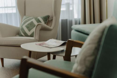 a living room with chairs and a table with a book on it at Apartment Hotel Pfeifer in Gaschurn