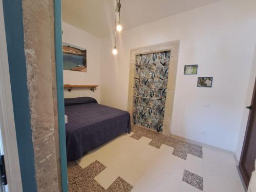 a small bedroom with a bed and a door at A Casa di Lu in Minervino di Lecce