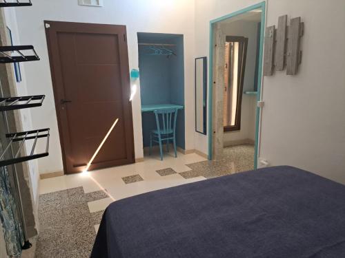 a room with a bed and a door and a table at A Casa di Lu in Minervino di Lecce