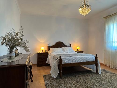 a bedroom with a bed and a table and two lamps at Villa Mendes Oliva in Almeida
