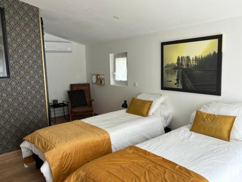 une chambre d'hôtel avec deux lits et une chaise dans l'établissement La Bonne Alt 303m, à Céret