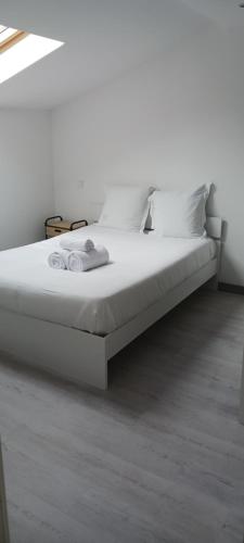 - un lit blanc avec des draps et des oreillers blancs dans l'établissement Cozy2, à Nancy