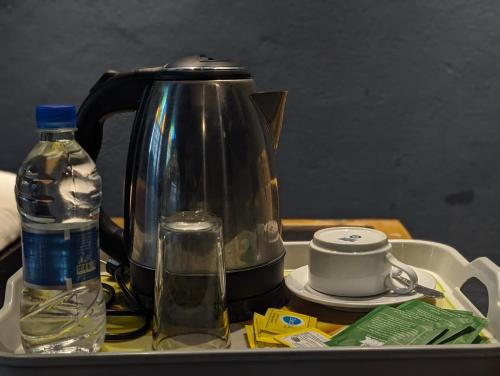 a tea kettle and a bottle of water on a tray at Hotel Hoque Tower International in Chittagong